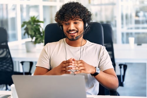 a-call-center-worker-sitting-at-a-laptop-in-the-of-2023-11-27-05-27-22-utc